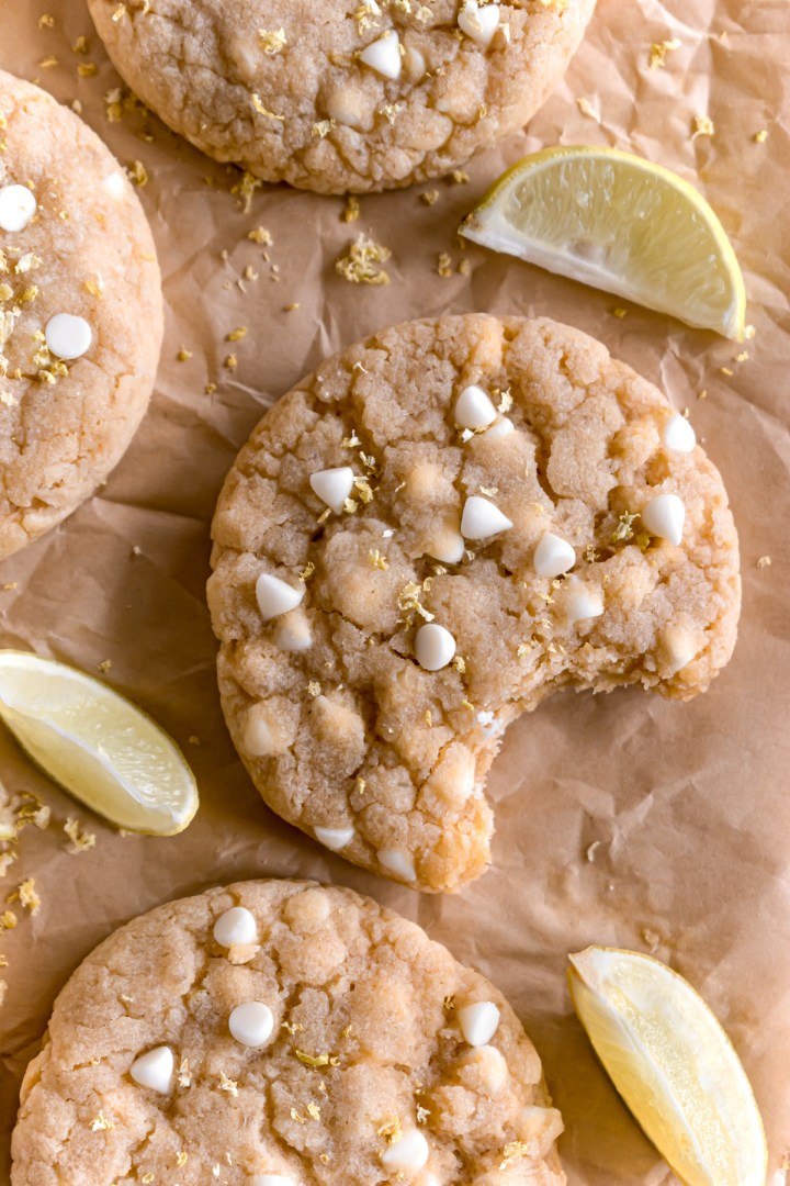 lemon and white chocolate cookies on a parchment paper with a bite taken