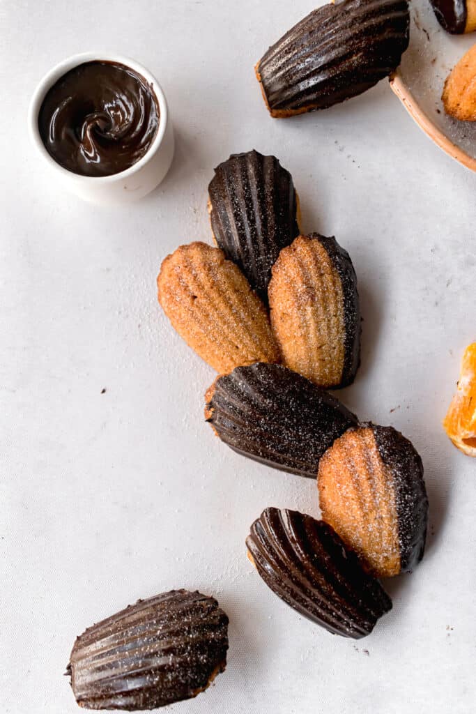 Chocolate glazed orange madeleines on a white marble