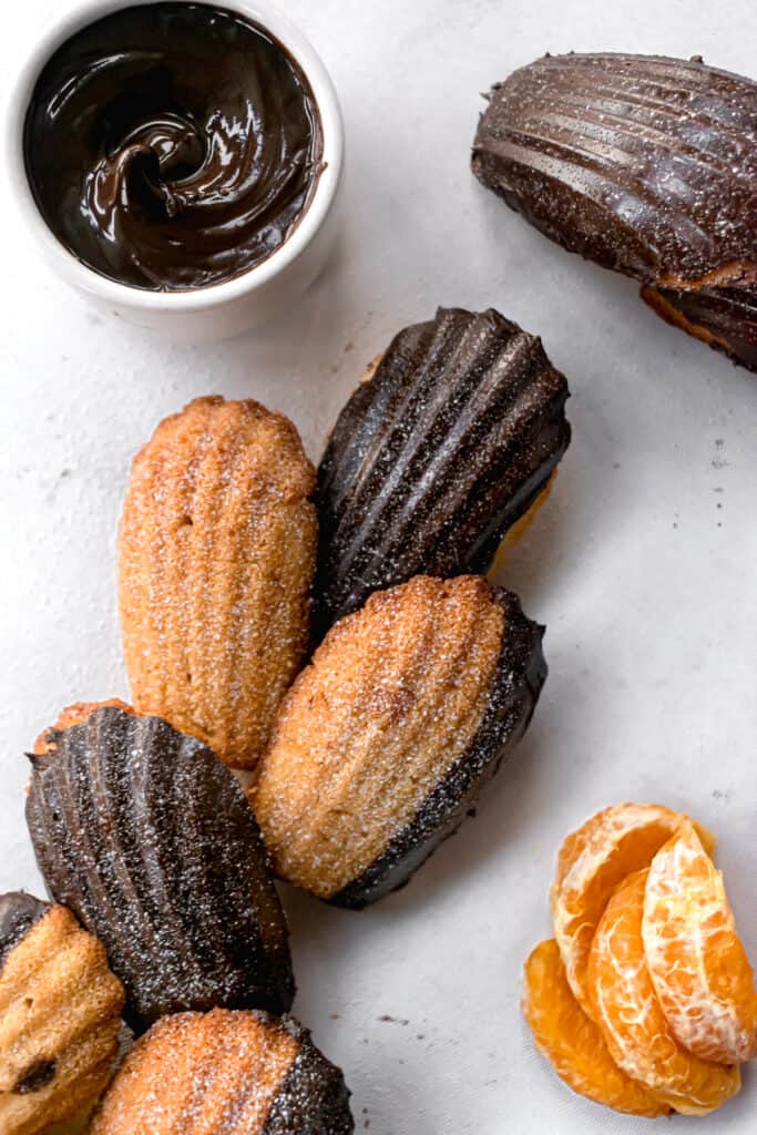 Chocolate glazed orange madeleines on a white marble