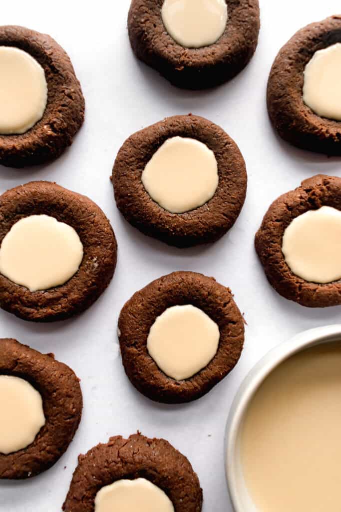 Dark chocolate tahini thumbprint cookies on a white marble