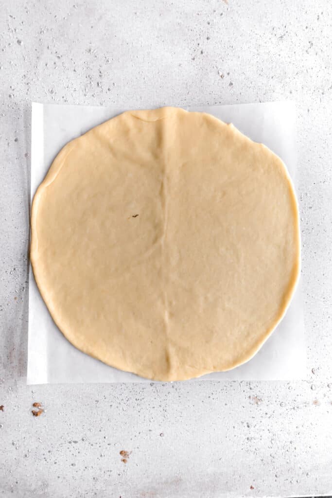 yeast dough for star bread on a parchment paper rolled out into a circle