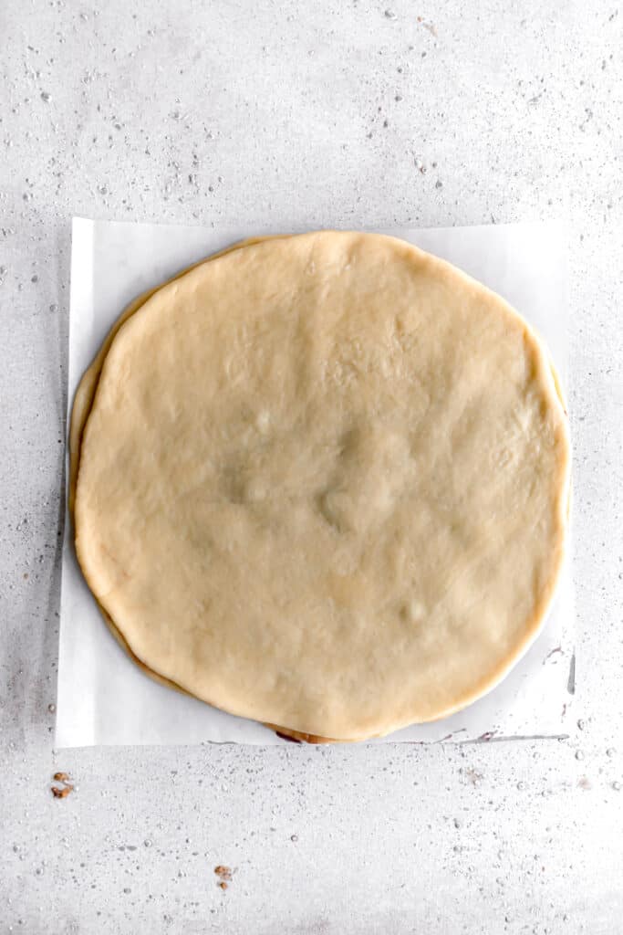 yeast dough for star bread on a parchment paper rolled out into a circle and layered