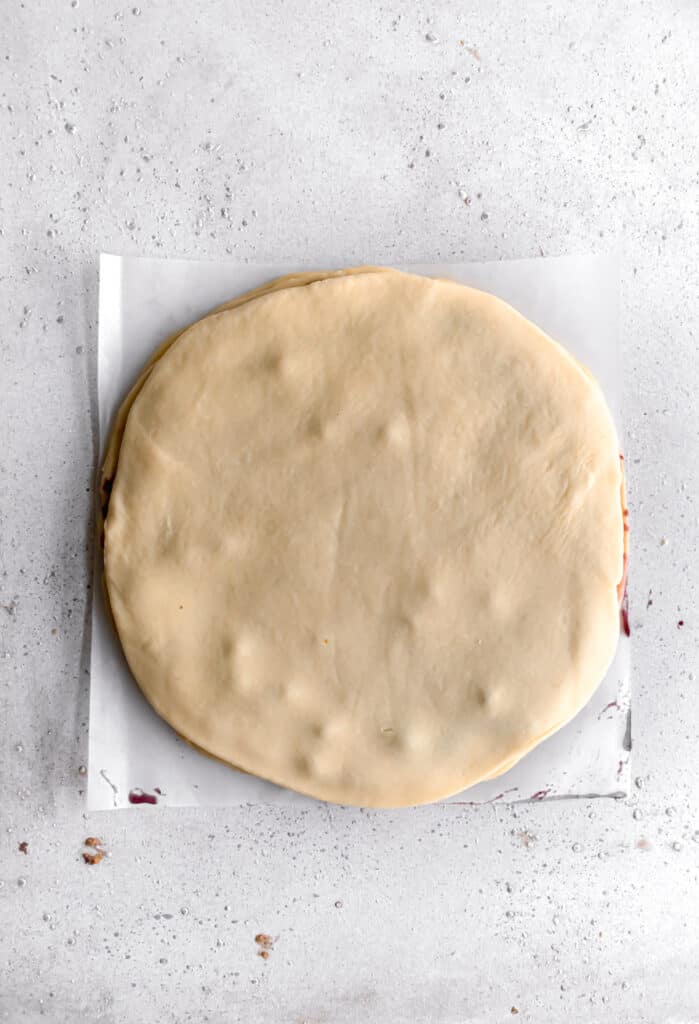 yeast dough for star bread on a parchment paper rolled out into a circle and layered