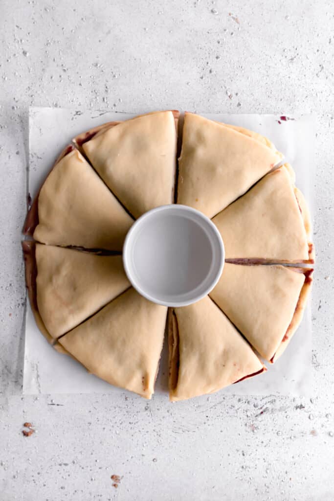 yeast dough for star bread on a parchment paper rolled out into a circle and cut into 8 parts