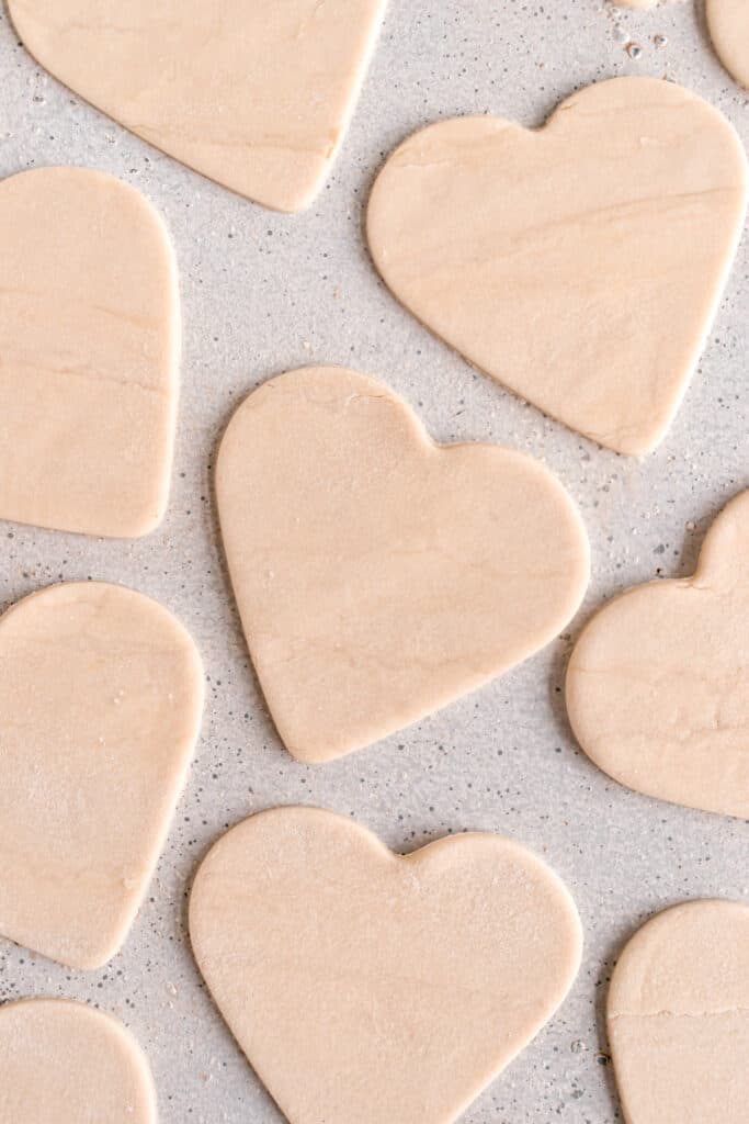 Pie dough cut into hearts with a heart shaped cookie cutter 