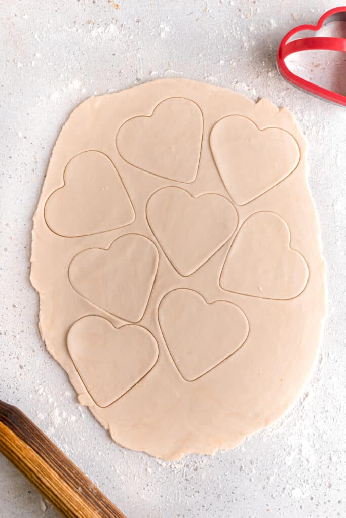 Pie dough cut into hearts with a heart shaped cookie cutter 